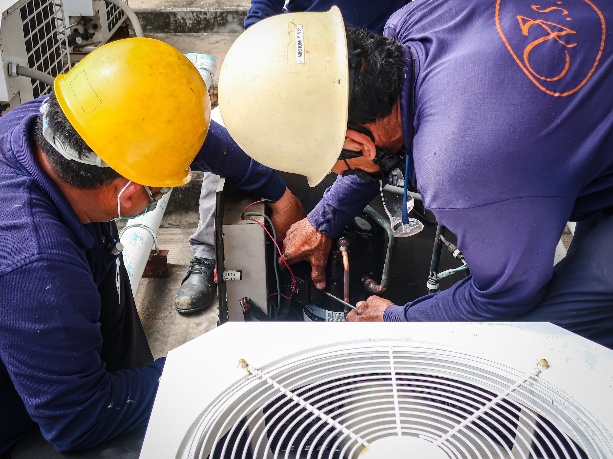 Maintenance man repair air conditional and air compressor of the factory.