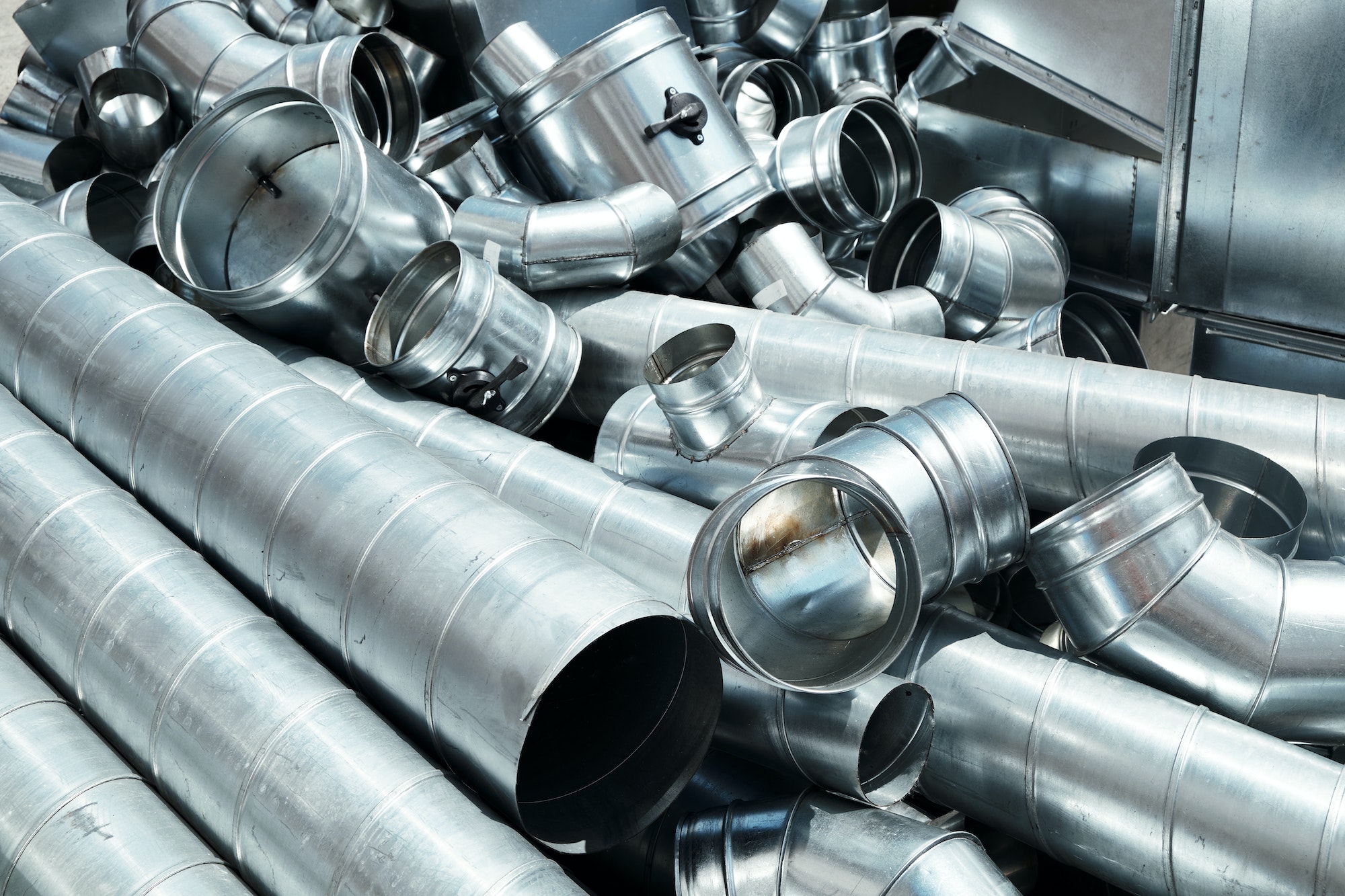 Pile of pipes and parts for duct systems. Industrial ventilation